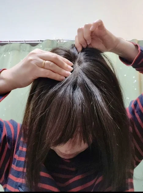 ヘアピース後ろのクリップを留めている様子